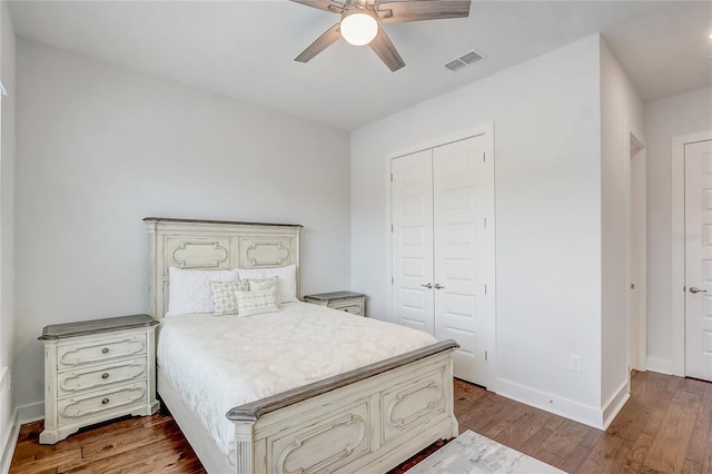 bedroom with hardwood / wood-style flooring, ceiling fan, and a closet