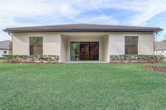 rear view of property featuring a lawn