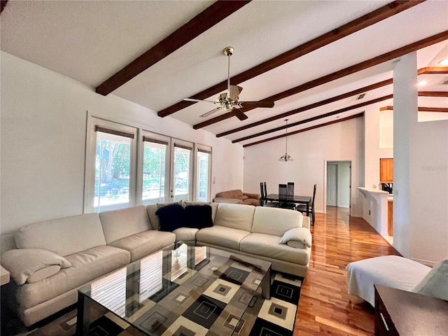 living room featuring ceiling fan, lofted ceiling with beams, and light wood-type flooring