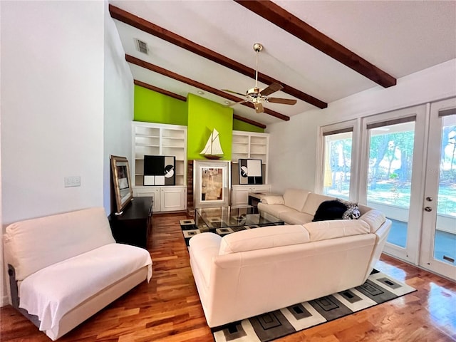 living room featuring ceiling fan, dark hardwood / wood-style floors, and vaulted ceiling with beams