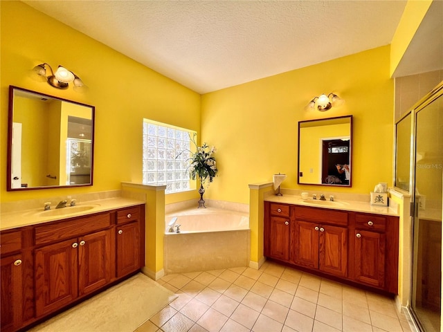 bathroom with vanity, tile patterned floors, plus walk in shower, and a textured ceiling