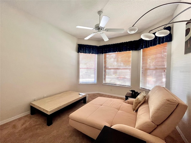 bedroom with ceiling fan, carpet floors, and a textured ceiling