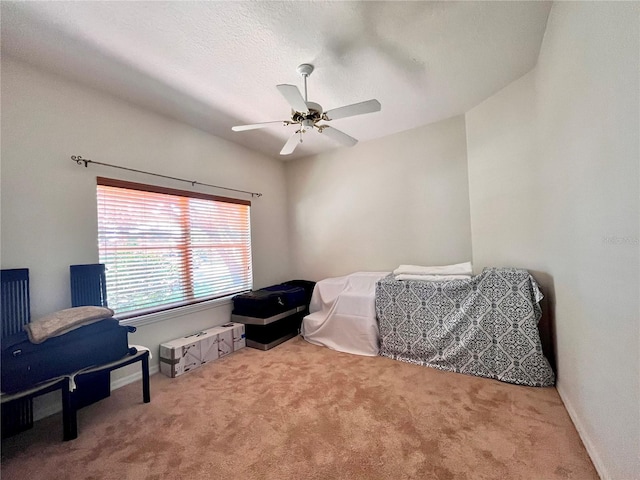 sitting room with ceiling fan, light colored carpet, and a textured ceiling