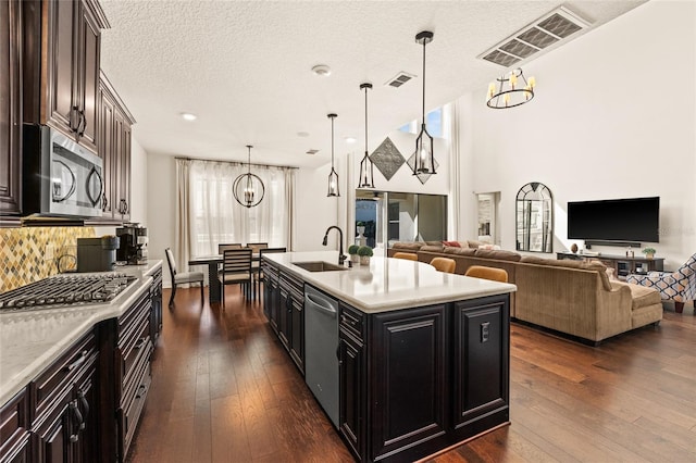 kitchen featuring sink, decorative light fixtures, a center island with sink, dark hardwood / wood-style floors, and stainless steel appliances