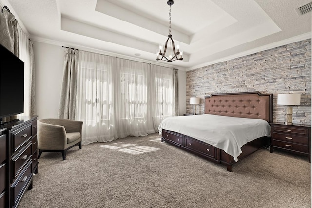 carpeted bedroom with a raised ceiling and a chandelier