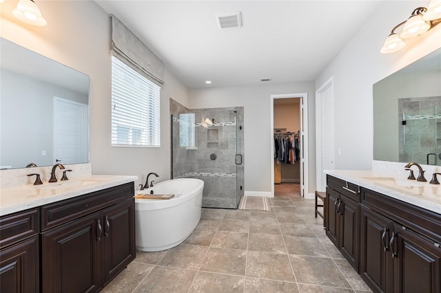 bathroom with vanity, tile patterned flooring, and plus walk in shower