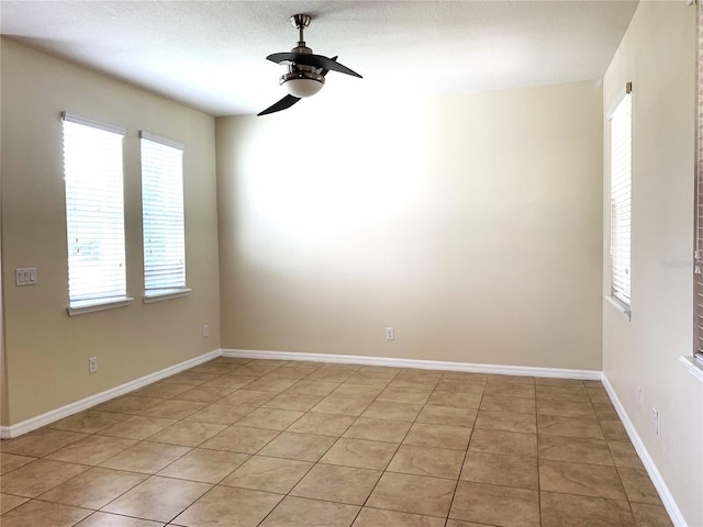 empty room featuring light tile patterned floors and ceiling fan