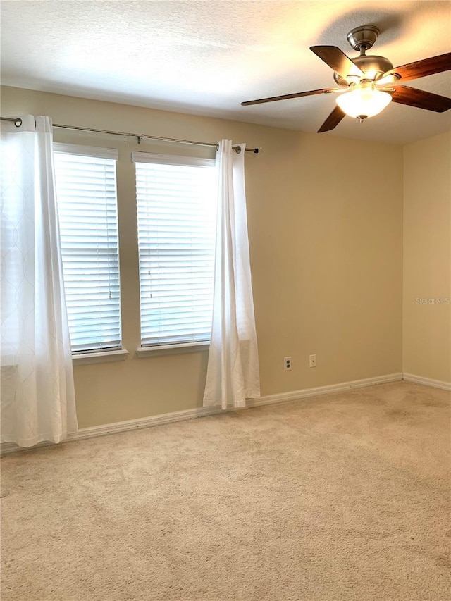 carpeted empty room featuring ceiling fan and a textured ceiling