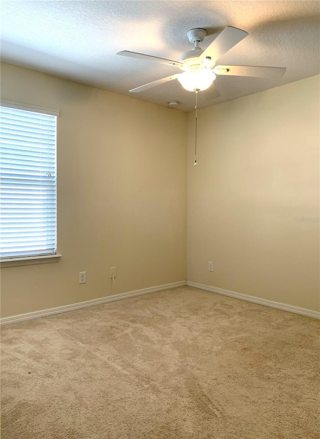 carpeted empty room featuring ceiling fan and a textured ceiling