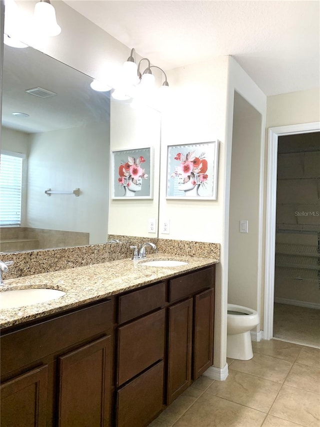 bathroom featuring tile patterned flooring, vanity, and toilet