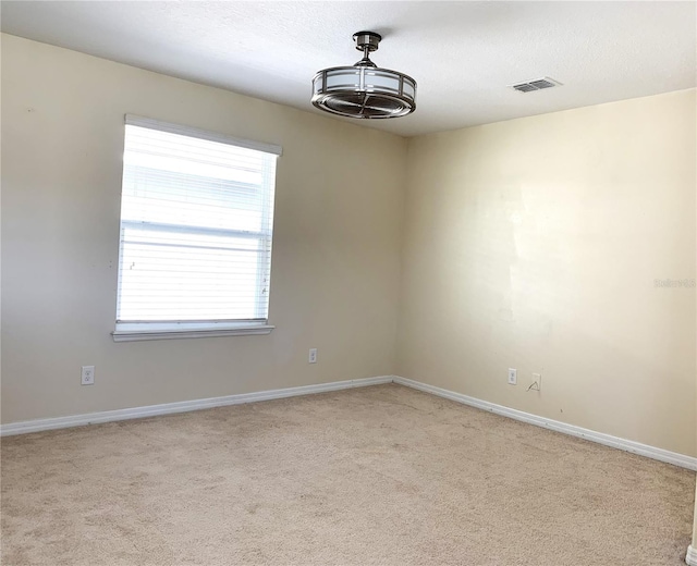 carpeted spare room with a textured ceiling