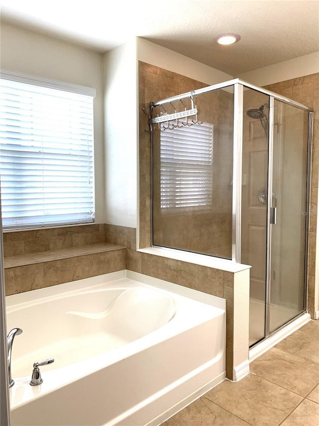 bathroom featuring independent shower and bath, tile patterned flooring, and a textured ceiling