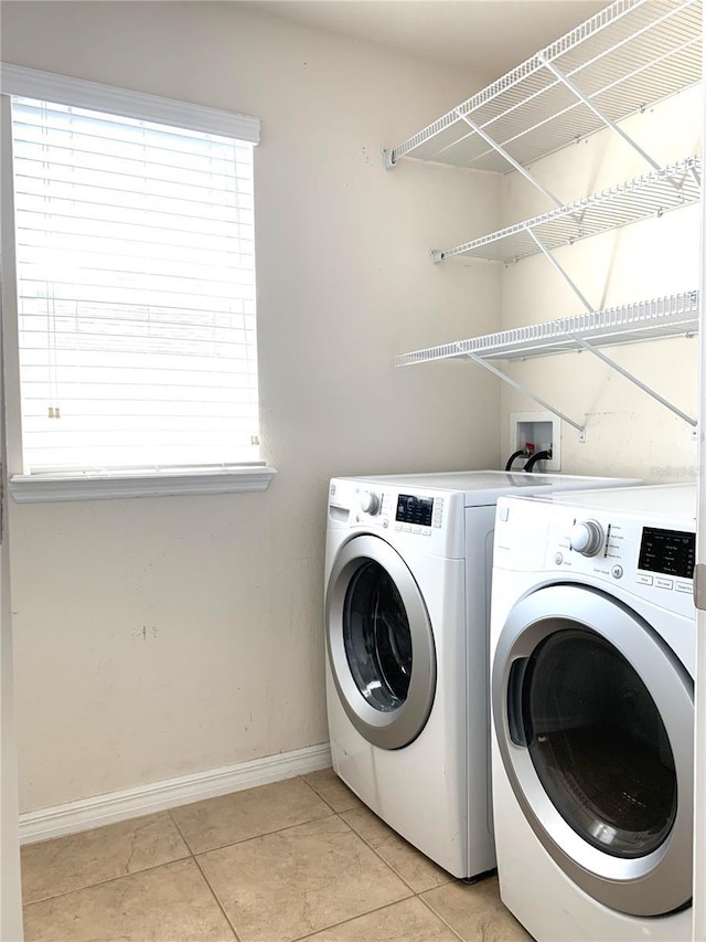 laundry room featuring light tile patterned flooring and separate washer and dryer