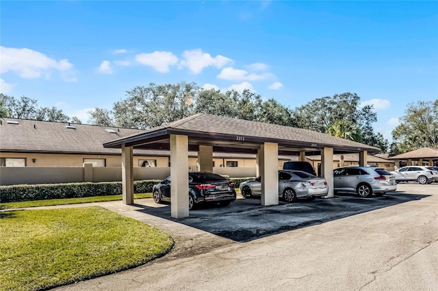 view of car parking featuring a yard and a carport