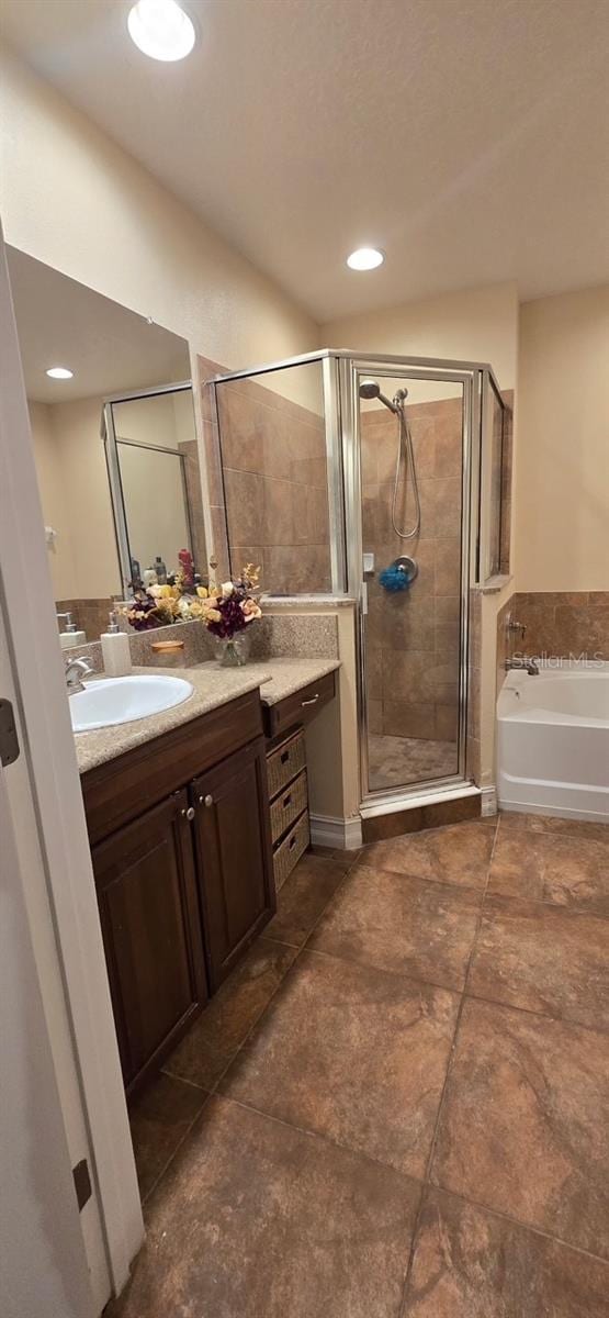 bathroom featuring vanity and shower with separate bathtub