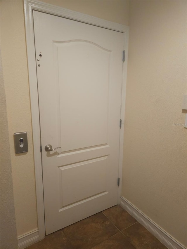 entryway with dark tile patterned flooring