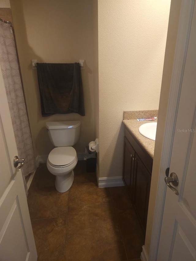 bathroom with vanity, toilet, and tile patterned flooring