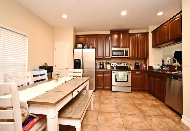 kitchen with backsplash, sink, and appliances with stainless steel finishes