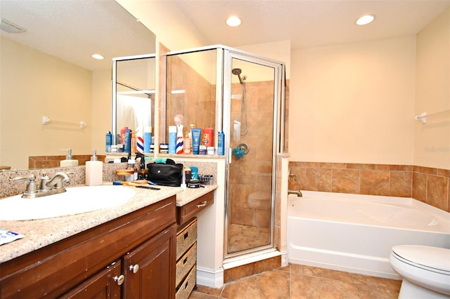 full bathroom featuring tile patterned flooring, vanity, shower with separate bathtub, and toilet