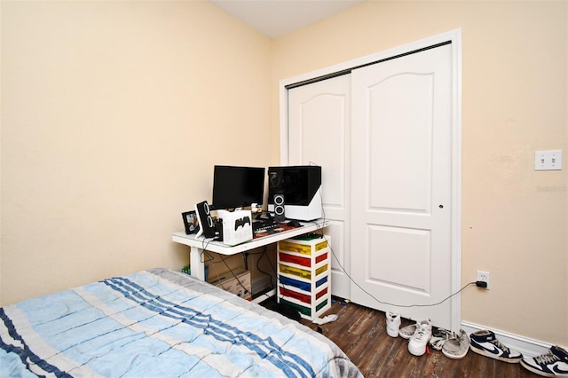 bedroom with dark hardwood / wood-style flooring and a closet