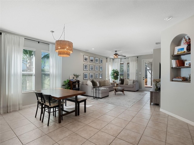 dining area featuring light tile patterned floors, a textured ceiling, and ceiling fan