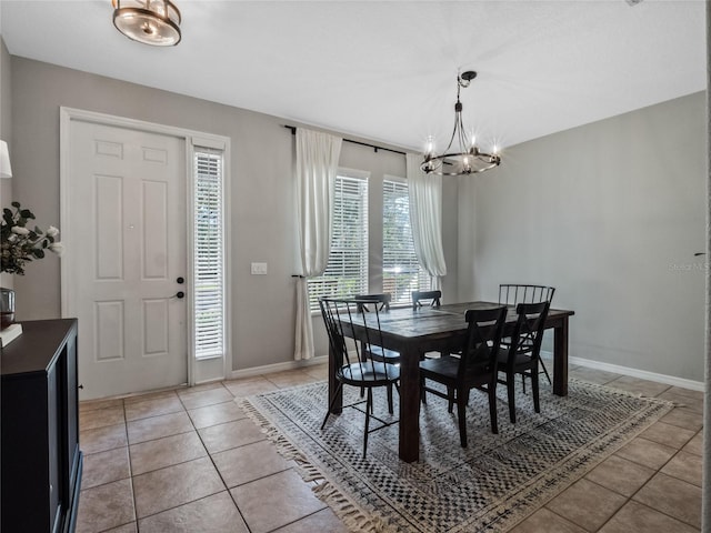 tiled dining room with a notable chandelier