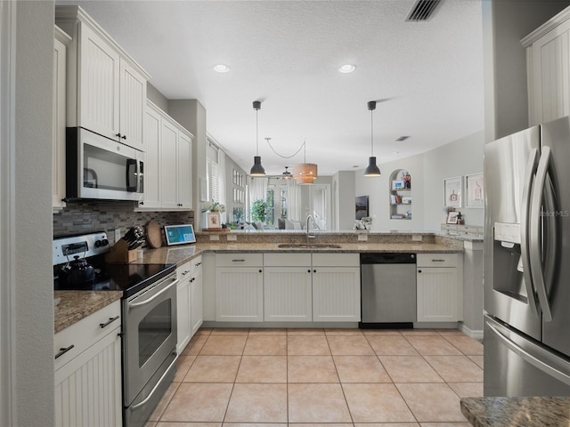 kitchen with sink, hanging light fixtures, stainless steel appliances, white cabinets, and light tile patterned flooring