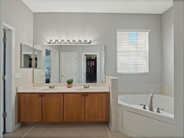 bathroom with tile patterned flooring, vanity, and a tub to relax in