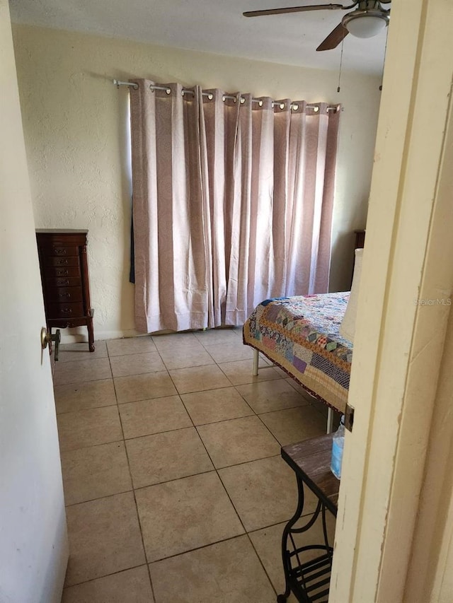 bedroom featuring light tile patterned flooring and ceiling fan