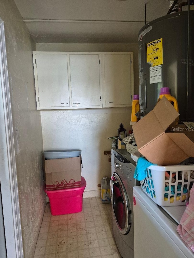 clothes washing area with cabinets and washer and dryer