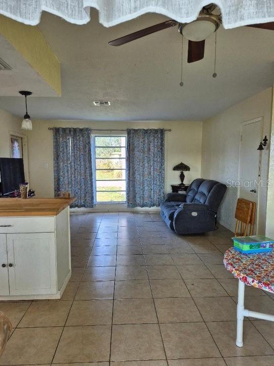 living room featuring ceiling fan and light tile patterned flooring