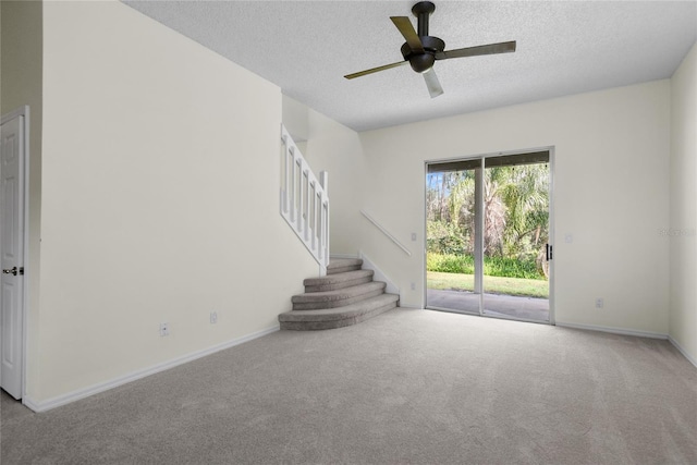 interior space with ceiling fan, light carpet, and a textured ceiling