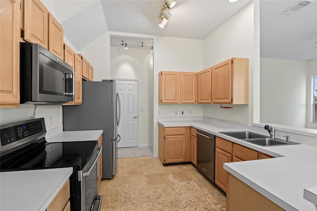 kitchen with rail lighting, sink, stainless steel appliances, light brown cabinets, and a textured ceiling