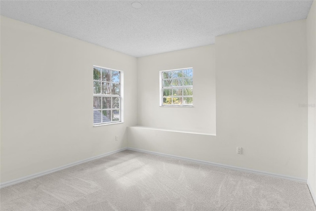 carpeted spare room with a textured ceiling