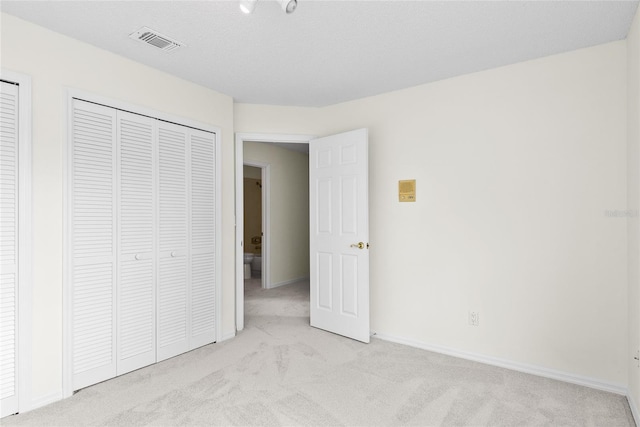 unfurnished bedroom featuring light carpet