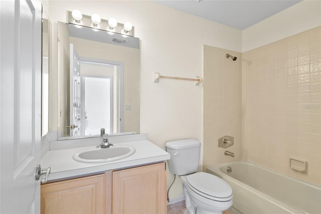 full bathroom featuring vanity, tiled shower / bath combo, and toilet