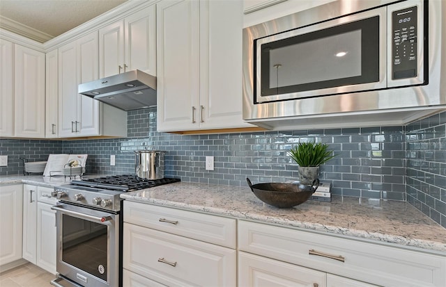 kitchen with white cabinetry, stainless steel appliances, light stone countertops, and backsplash