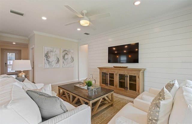 living room with ceiling fan and ornamental molding