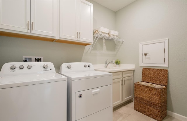 washroom with cabinets, sink, and washer and clothes dryer