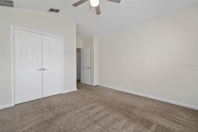 unfurnished bedroom with vaulted ceiling, carpet, ceiling fan, and a closet