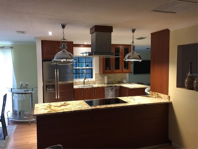 kitchen with appliances with stainless steel finishes, pendant lighting, island exhaust hood, light stone counters, and kitchen peninsula