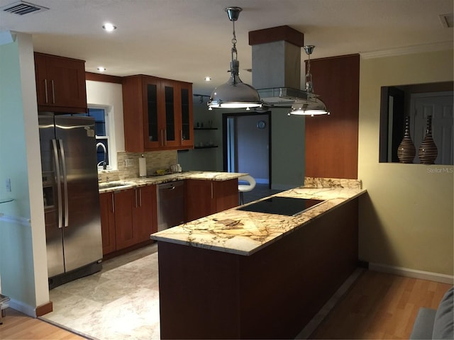 kitchen with sink, stainless steel fridge with ice dispenser, black electric cooktop, kitchen peninsula, and pendant lighting