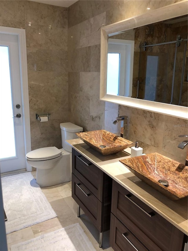 bathroom featuring walk in shower, toilet, tasteful backsplash, tile walls, and vanity