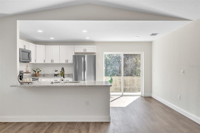 kitchen with white cabinetry, light stone countertops, stainless steel appliances, and hardwood / wood-style floors