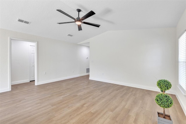 unfurnished room featuring ceiling fan, lofted ceiling, a textured ceiling, and light wood-type flooring