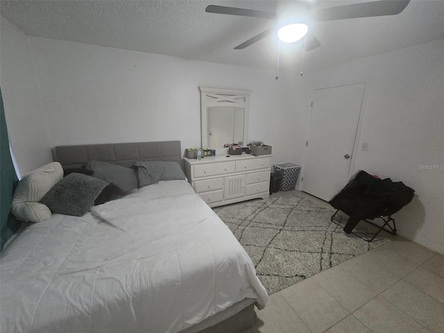 bedroom featuring light tile patterned floors, a textured ceiling, and ceiling fan