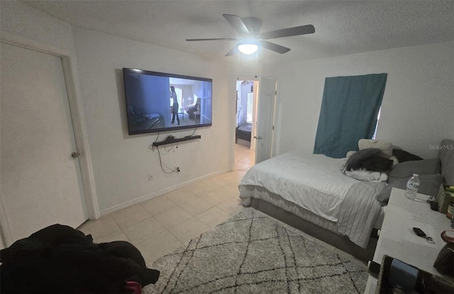 bedroom featuring ceiling fan, a textured ceiling, and light tile patterned floors