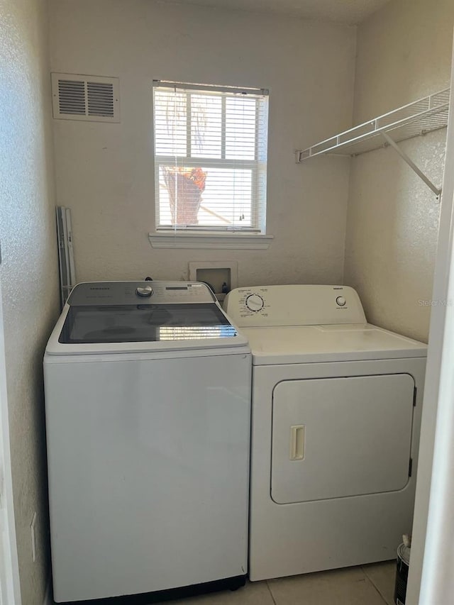 laundry room featuring light tile patterned floors and washing machine and clothes dryer