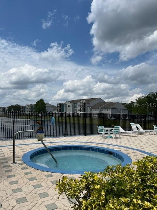 view of swimming pool with a patio area and a hot tub