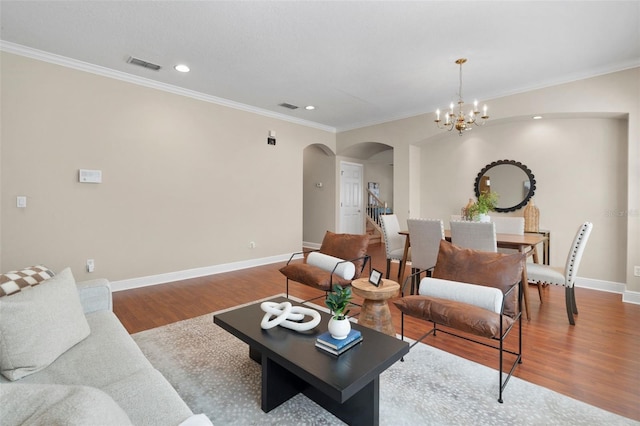 living room featuring crown molding, an inviting chandelier, and hardwood / wood-style floors